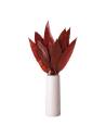 Feuilles tropicales stabilisées rouges dans un vase blanc haut, sur un meuble en bois